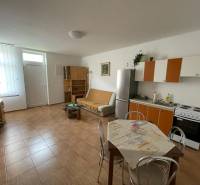 Családi ház belső tere konyhasarokkal és fa dekorációjú padlóval.