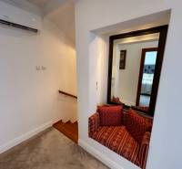 A családi ház lépcsőket mutat fa dekorral, tükröt és ülősarkot párnákkal.