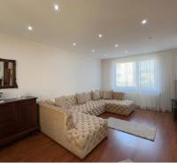 Nappali nagy kanapéval, fa dekoros padlóval és antik bútorokkal.