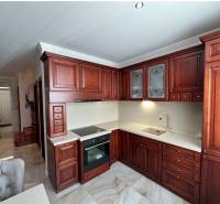 Konyha sötét fa szekrényekkel és fa dekorációjú padlóval egy családi házban.