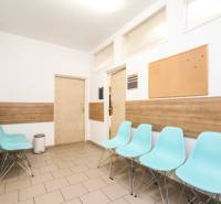 Váróterem kék székekkel, parafatáblával és fa dekor padlóval az irodában.