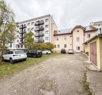 Parkoló és épületek a Zsolnai Pozsonyi utcában, irodák és lakóházak.