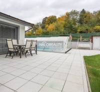 A domanižai családi ház terasza kerti bútorokkal és fedett medencével.