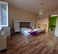 Gyerekszoba egy családi házban ággyal, kisággyal és fa dekorációjú padlóval.