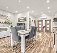 Étkező sarok egy háromszobás lakásban, fa dekoros padlóval és stílusos tükörrel.