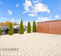 Parkolóhely egy háromszobás lakásnál Gabčíkovo-ban, autókkal és fa garázzsal.