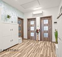 3 szobás lakás belső tere fa dekorációjú padlóval és fehér bútorokkal.