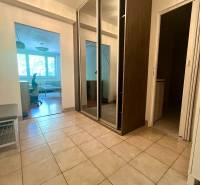 Folyosó csempézett padlóval és beépített szekrénnyel egy háromszobás lakásban.