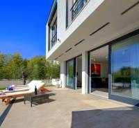 Villa Balin terasszal, napozóágyakkal, asztallal és medencével, amelyet zöld növényzet vesz körül.