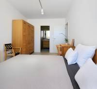 Hálószoba a villában fa bútorokkal, asztallal, székkel és kilátással a fürdőszobára.