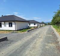 Családi házak a Felsősebes utcában, Eperjesen, zölddel körülvéve, egy befejezetlen út mellett.