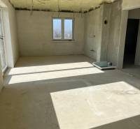 Tágas szoba egy családi házban a Vyšná Šebastová utcán, nyers vakolattal és kábelekkel.