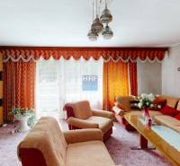 Nappali egy családi házban narancssárga függönyökkel és stílusos berendezéssel.