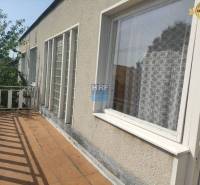 Családi ház erkélye a Vieska utcában, Radošovce városában, fa korláttal.