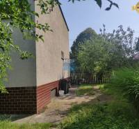 Kert a családi ház mellett Vieskán, Radošovcén, járdával és kerítéssel.