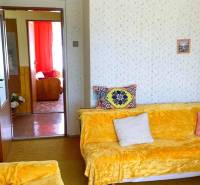 Nappali egy családi házban színes takarókkal és párnázott ülőgarnitúrával.