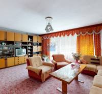 Nappali a családi házban kanapéval, nappali szekrénnyel és virágokkal.