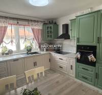 Konyha családi házban fa bútorokkal és függönyökkel.