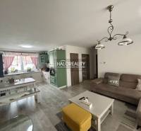 Nappali családi házban kanapéval, asztallal és konyhabútorral.