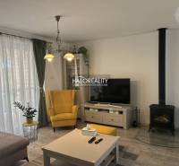 Nappali egy családi házban kandallóval, sárga fotellel és televízióval.