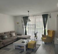 Nappali egy családi házban kényelmes kanapéval és sárga fotellel.