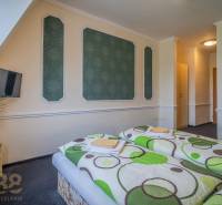 Szoba szállodákban és panziókban két ággyal, televízióval és virágokkal az asztalon.