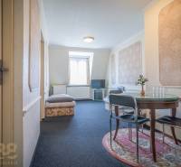 Szoba szállodákban és panziókban kerek asztallal és állványra helyezett televízióval.