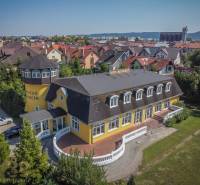 Sárga szálloda toronnyal, kerttel körülvéve Poprádon, szállodák és panziók.