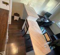 Konyha egy egyszobás lakásban fa dekorációjú padlóval, bárpulttal és munkalappal.