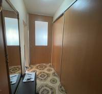 Az egy szobás lakás előszobájában van egy tükör, egy ruhásszekrény és mintás padlóburkolat.