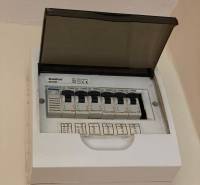 Elektromos elosztószekrény nyitott fedéllel és jelölt megszakítókkal egy egyszobás lakásban.