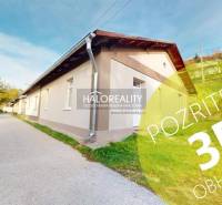 Családi ház Sirkben hosszú homlokzattal, zöld gyep és hozzáférési út az oldalán.