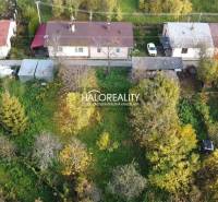 Családi ház Sirken, zölddel és fákkal körülvéve, egyszintes épületekkel.