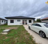 Családi ház Újvárosban, a felhajtón parkoló autóval.