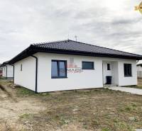 Családi ház egy utcában Újvárosban, fehér homlokzattal és sötét tetővel.