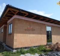 Családi ház Újvárosban, amely egy építés alatt álló épületet mutat tégla homlokzattal.