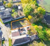 Telkek - lakóövezet a Jahodnában a folyó mellett, fákkal és gazdag növényzettel szegélyezve.