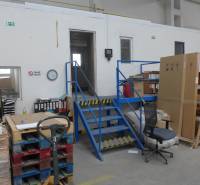 Raktárak és csarnokok lépcsővel, raklapokkal és irodai bútorokkal.