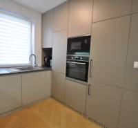 Konyha családi házban fa dekoros padlóval és beépített készülékekkel.