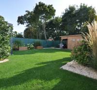 Családi ház kertje a Miloslavov-i Ďuríčkova utcában, fa pavilonnal és zöld növényzettel.