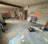 Befejezetlen szoba egy családi házban, kerékpárral és polcokkal különféle szerszámok számára.