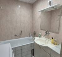 Fürdőszoba káddal, mosdóval és tükörrel egy háromszobás lakásban.