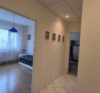 A háromszobás lakás hálószobájába vezető folyosó fa dekor padlóval.