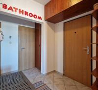 Előszoba egy háromszobás lakásban, ajtókkal és fogassal, padlón csempe.