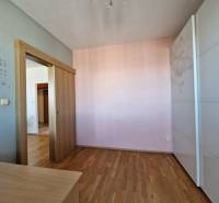 Gyerekszoba egy háromszobás lakásban, fa dekor padlóval és tolóajtókkal.