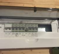 Elektromos elosztószekrény egy fahatású padlóval rendelkező házikóban.