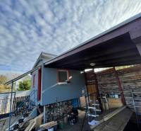 Ház Komáromban, az Újtelepen, lépcsővel és fa menedékkel a felhők alatt.