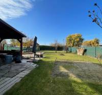 Kert a ház mellett az Új telep utcában, Komáromban, gyepes területtel és pavilonnal.