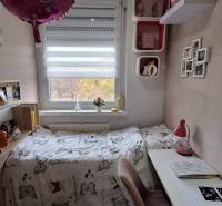 Gyerekszoba egy háromszobás lakásban dekorációkkal és íróasztallal.