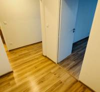 Belső tér fehér falakkal és fa dekorációjú padlóval egy egyszobás lakásban.